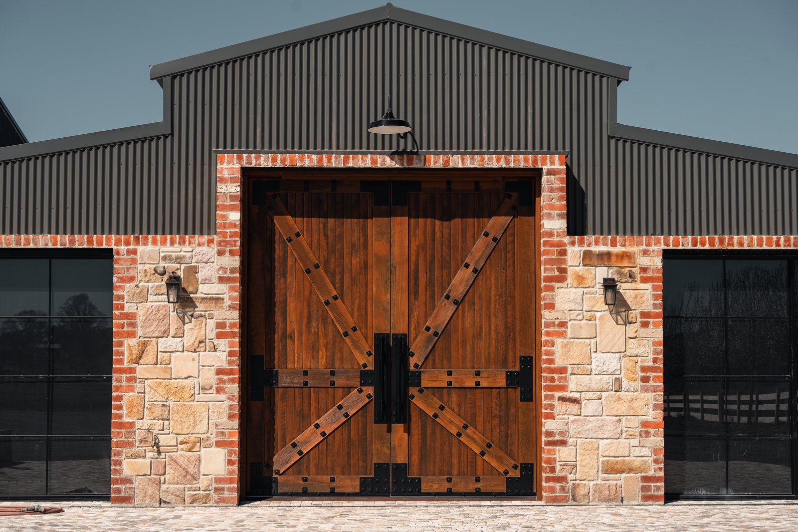 Timber barn pivot doors with wrought iron straps in a brick facade, Hardwood Projects, Best Pivot Door Contest, with FritsJurgens System M+ pivot hinge inside