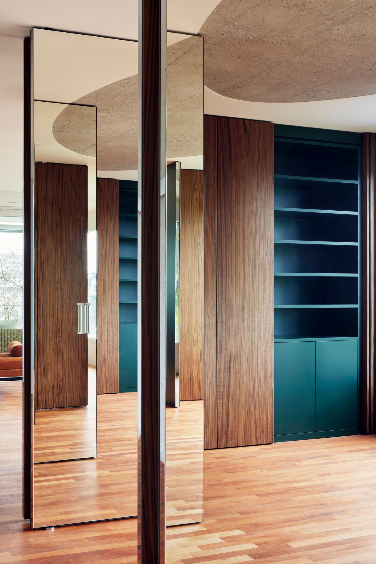 Mirrored pivot door in a private home with FritsJurgens System M pivot hinge system inside