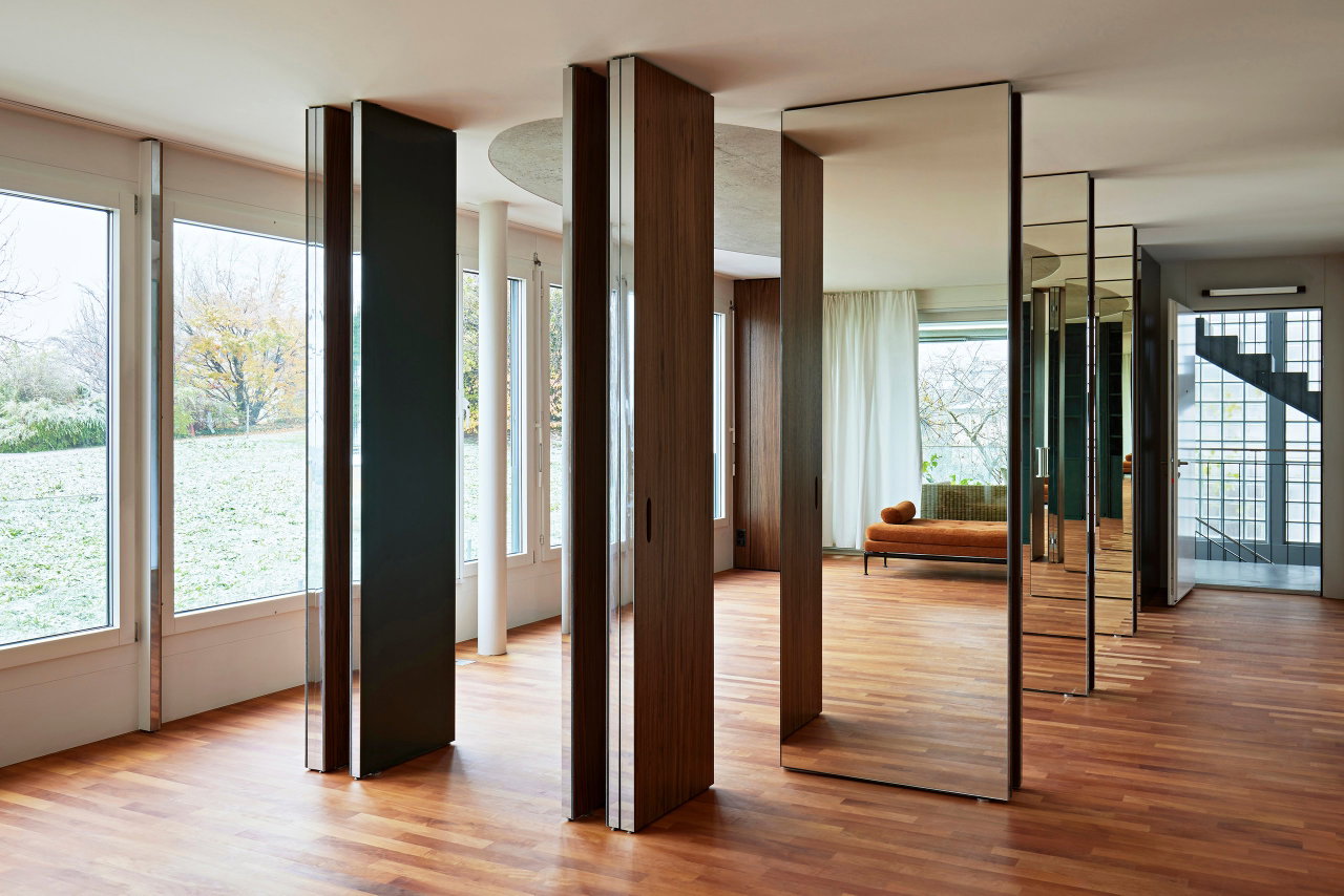 Mirrored pivot door in a private home with FritsJurgens System M pivot hinge system inside