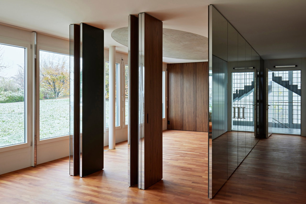 Mirrored pivot door in a private home with FritsJurgens System M pivot hinge system inside