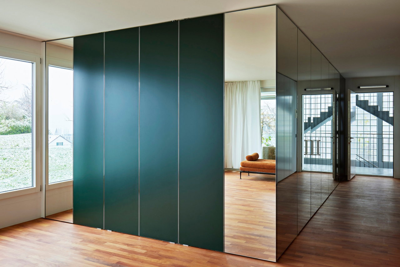 Mirrored pivot door in a private home with FritsJurgens System M pivot hinge system inside