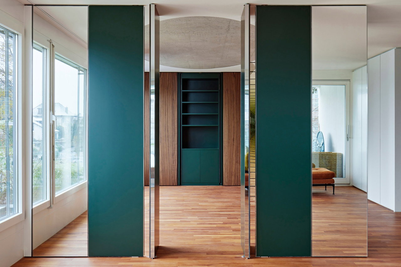 Mirrored pivot door in a private home with FritsJurgens System M pivot hinge system inside