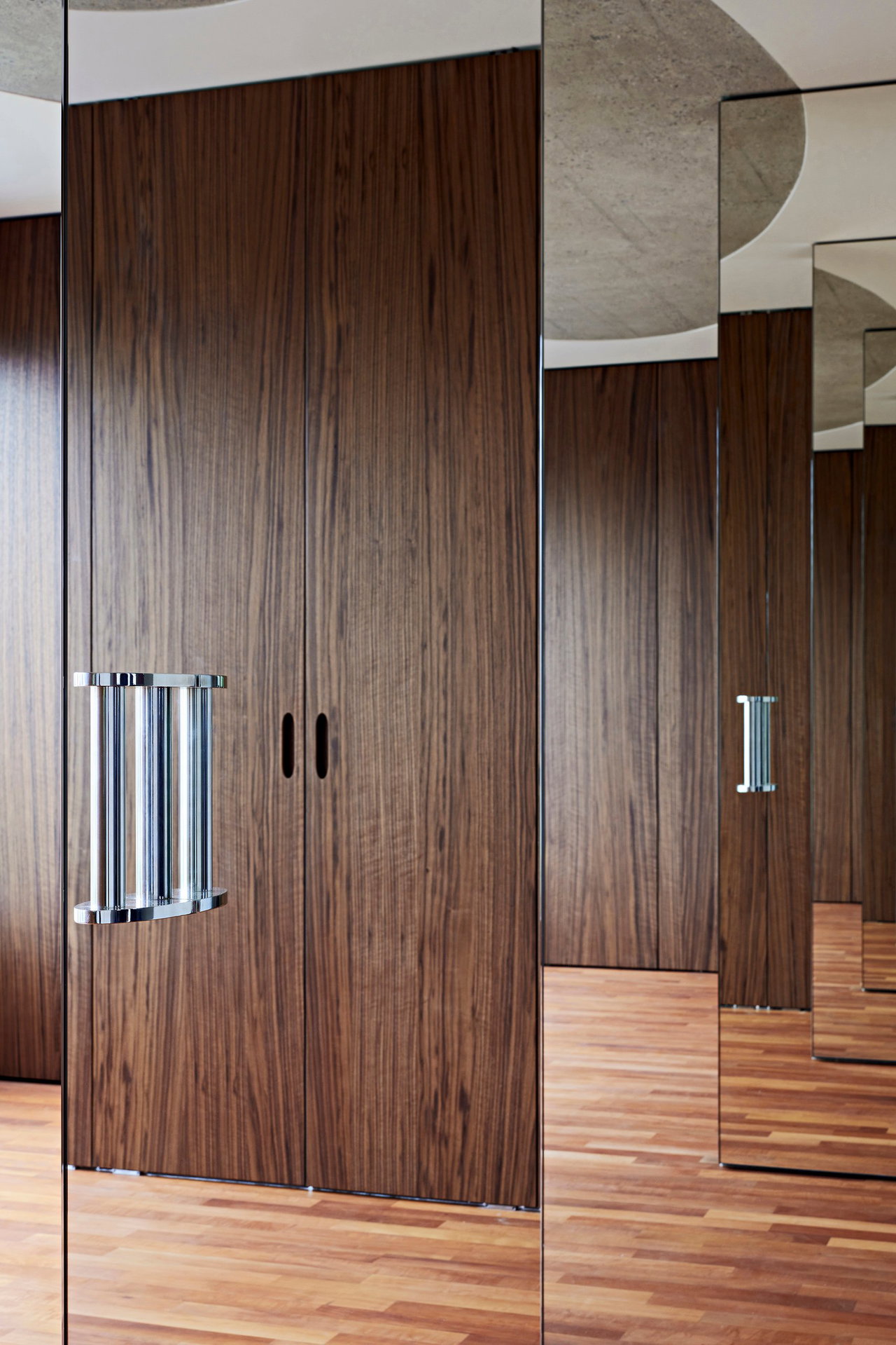 Mirrored pivot door in a private home with FritsJurgens System M pivot hinge system inside