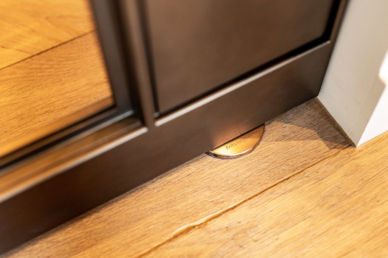 Steel and glass pivot door in a private home in Amsterdam with FritsJurgens System M pivot hinge system inside
