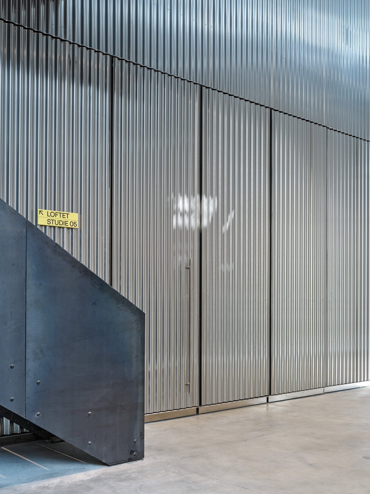 Steel pivot door in a public building in Copenhagen with FritsJurgens System M+ pivot hinge system inside
