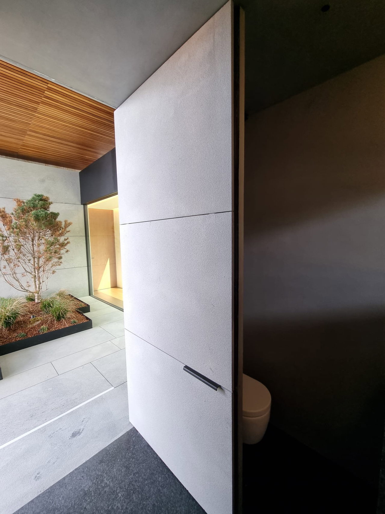 Stone pivot door in a private home in Cangas do Morrazo with FritsJurgens System M+ pivot hinge system inside