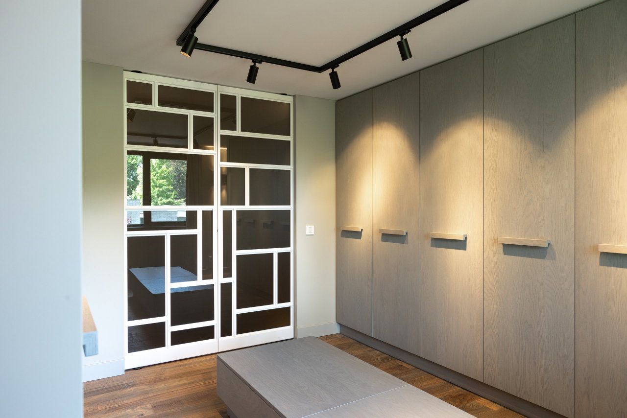 Steel and glass pivot door in a private home in Geldrop with FritsJurgens System M+ pivot hinge system inside