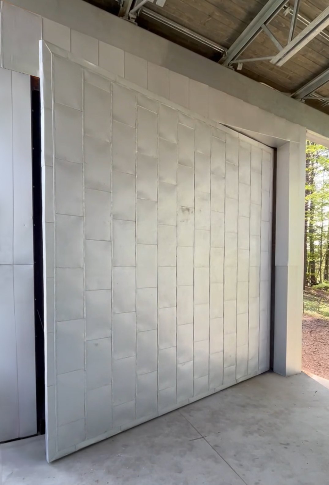 Steel pivot door in an outdoor public space in Winchendon with FritsJurgens System One pivot hinge system inside