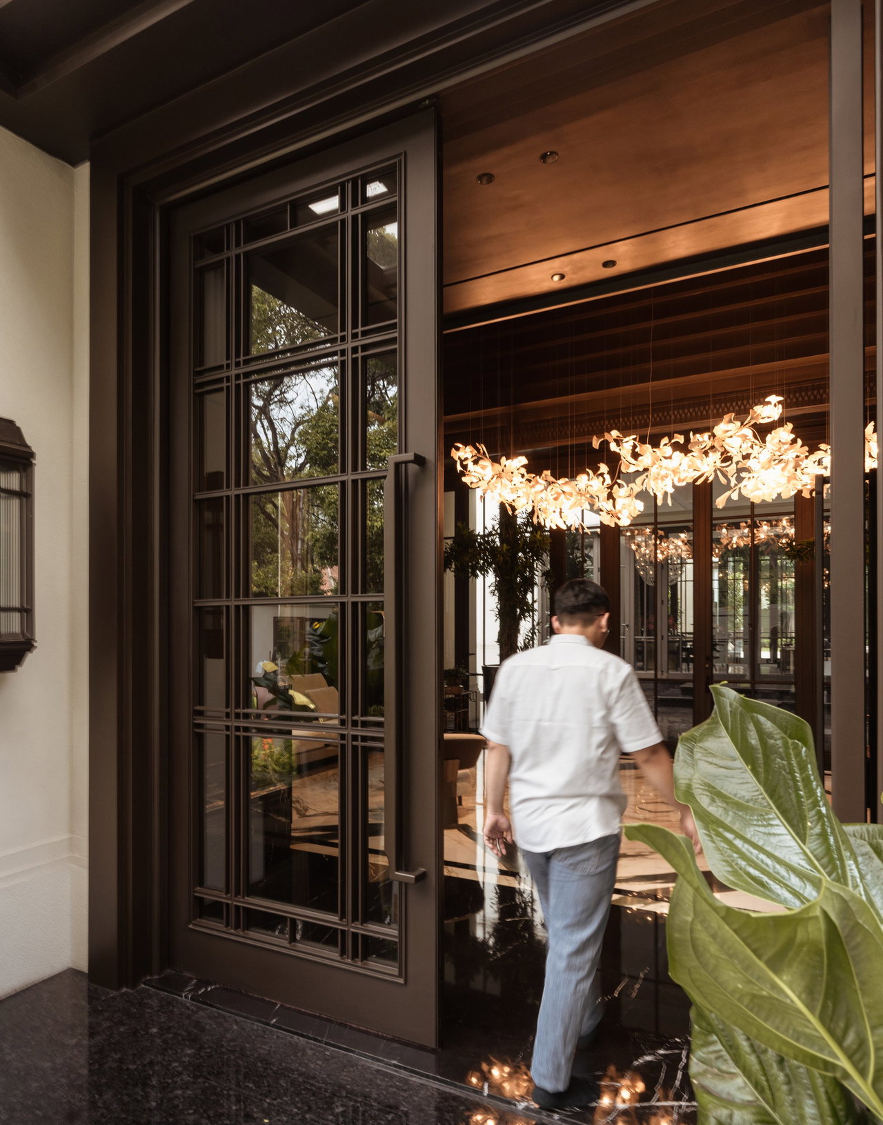Steel and glass pivot door in a private home in Jakarta with FritsJurgens System M+ pivot hinge system inside