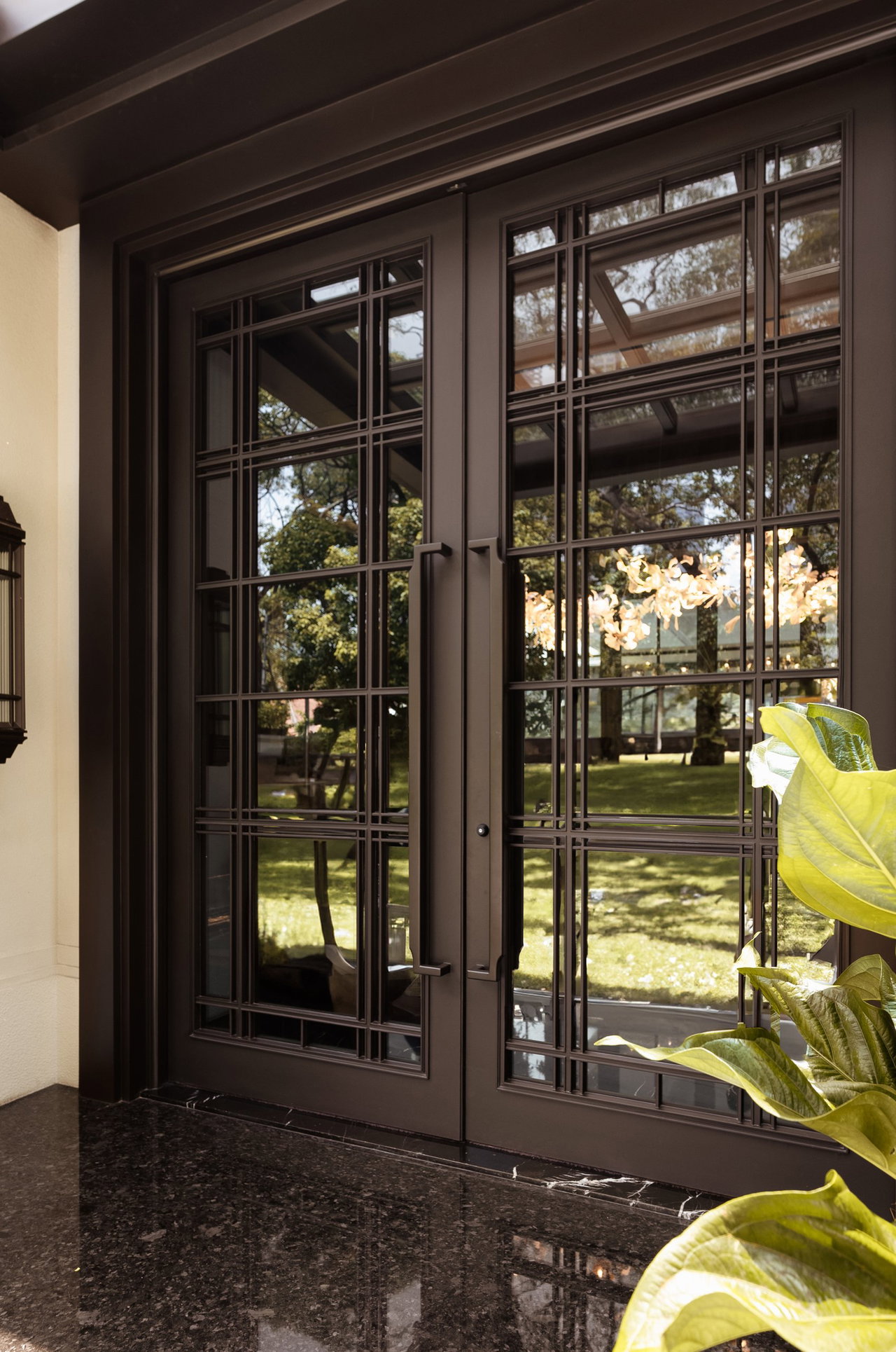 Steel and glass pivot door in a private home in Jakarta with FritsJurgens System M+ pivot hinge system inside