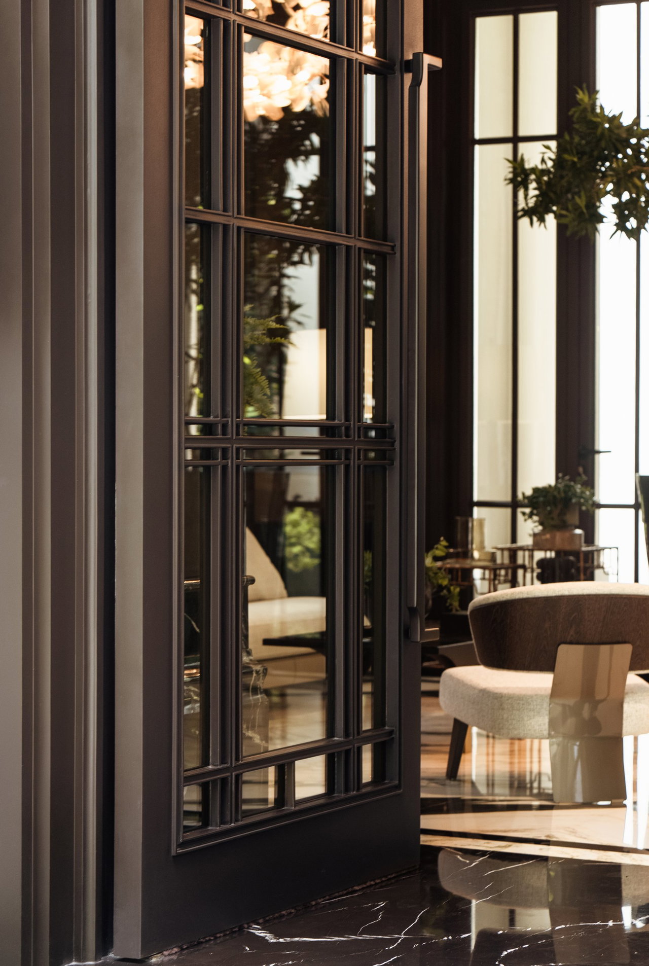 Steel and glass pivot door in a private home in Jakarta with FritsJurgens System M+ pivot hinge system inside