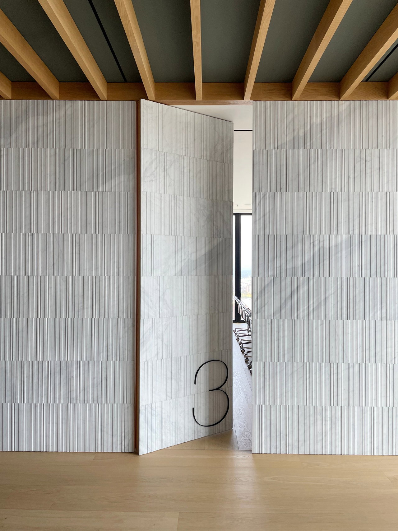 Stone pivot door in an office in Madrid with FritsJurgens System M+ pivot hinge system inside