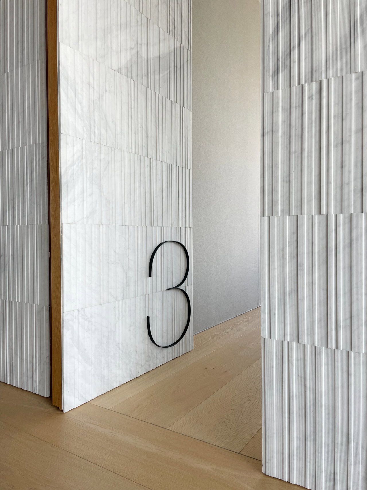 Stone pivot door in an office in Madrid with FritsJurgens System M+ pivot hinge system inside
