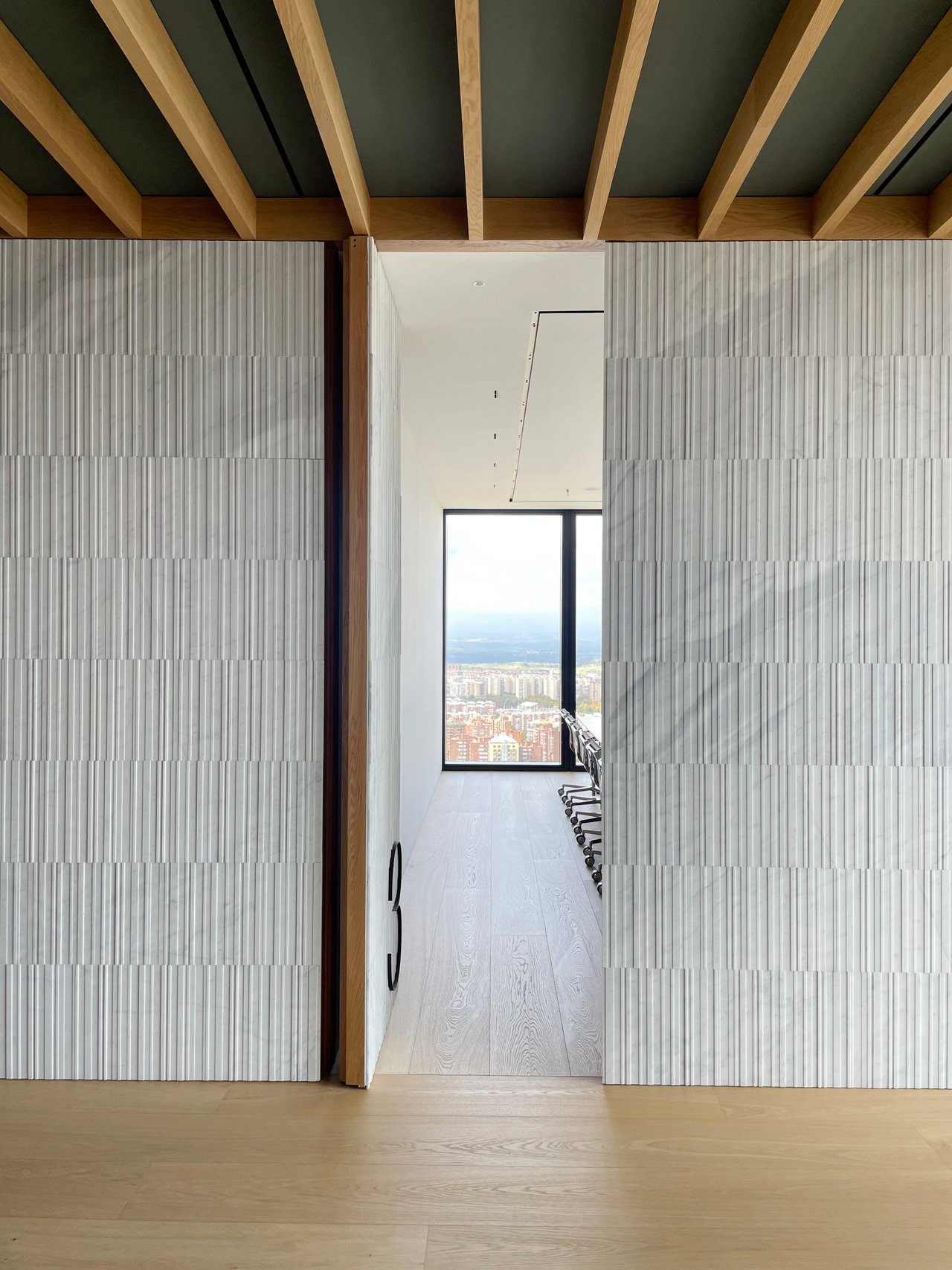 Stone pivot door in an office in Madrid with FritsJurgens System M+ pivot hinge system inside