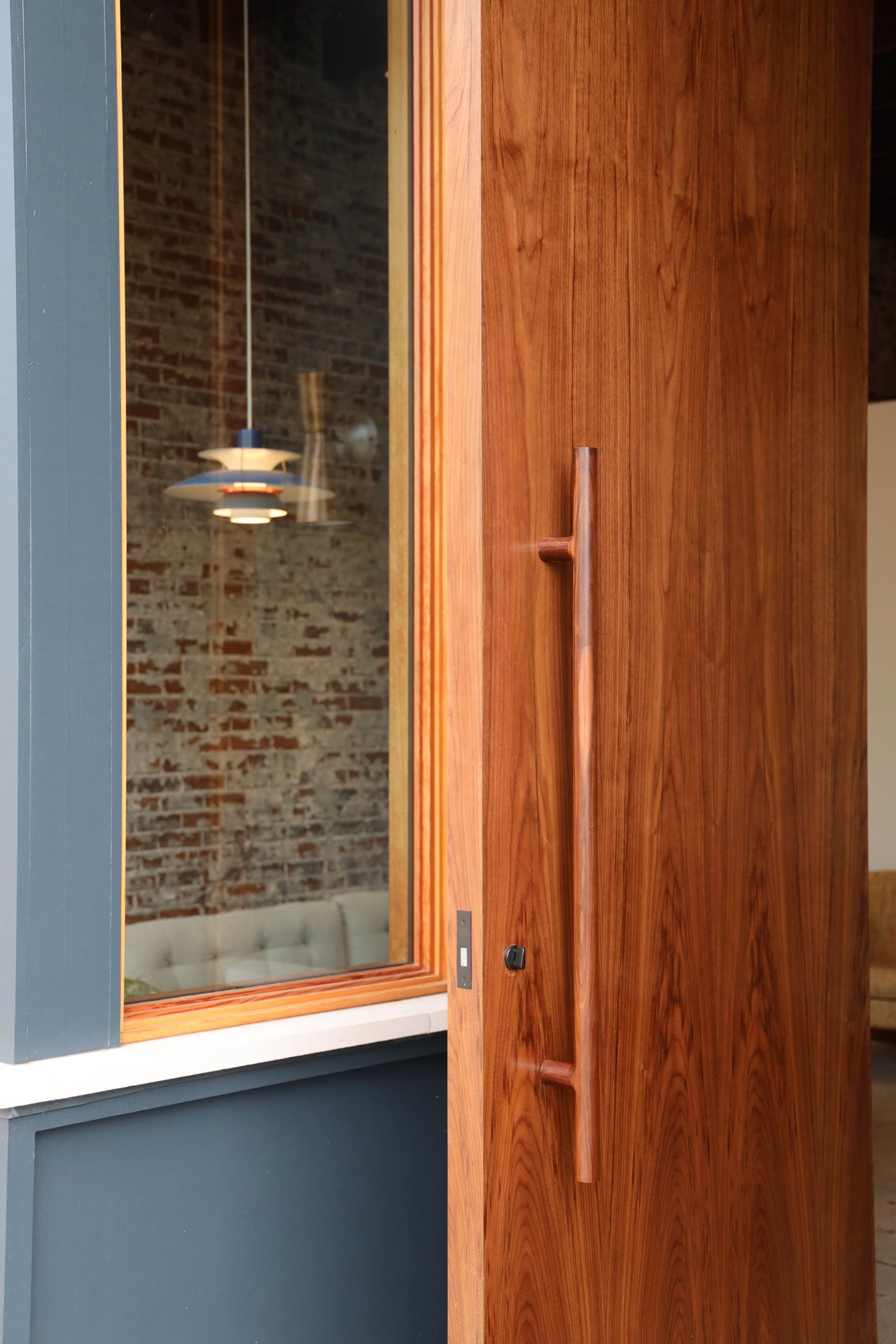 Wooden pivot door in an office in Athens with FritsJurgens System M+ pivot hinge system inside