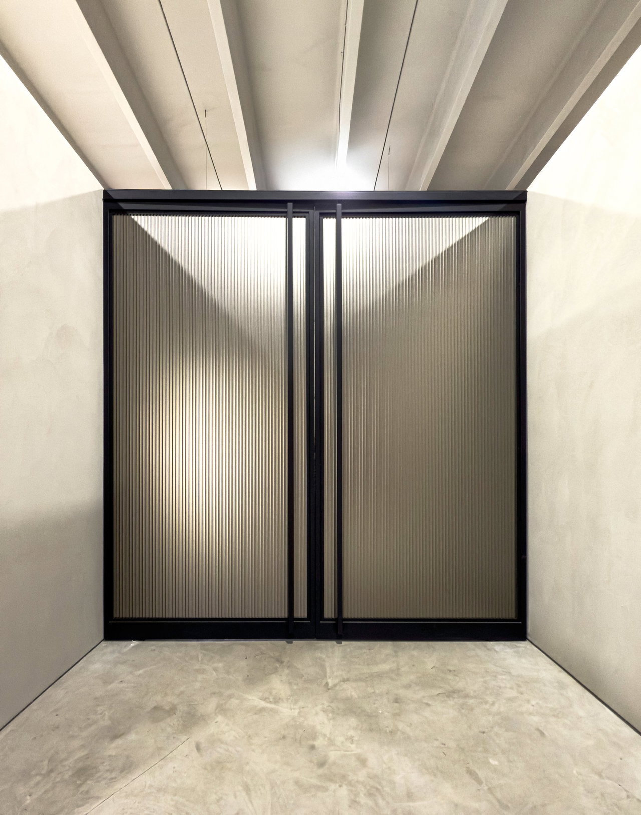 Steel and glass pivot door in a showroom in Miami with FritsJurgens System M+ pivot hinge system inside