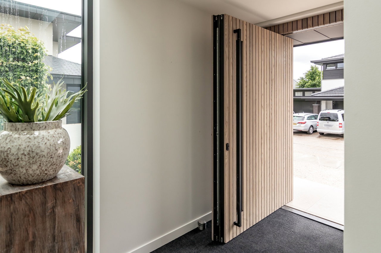 Wooden pivot door in a private home with FritsJurgens System M+ pivot hinge system inside