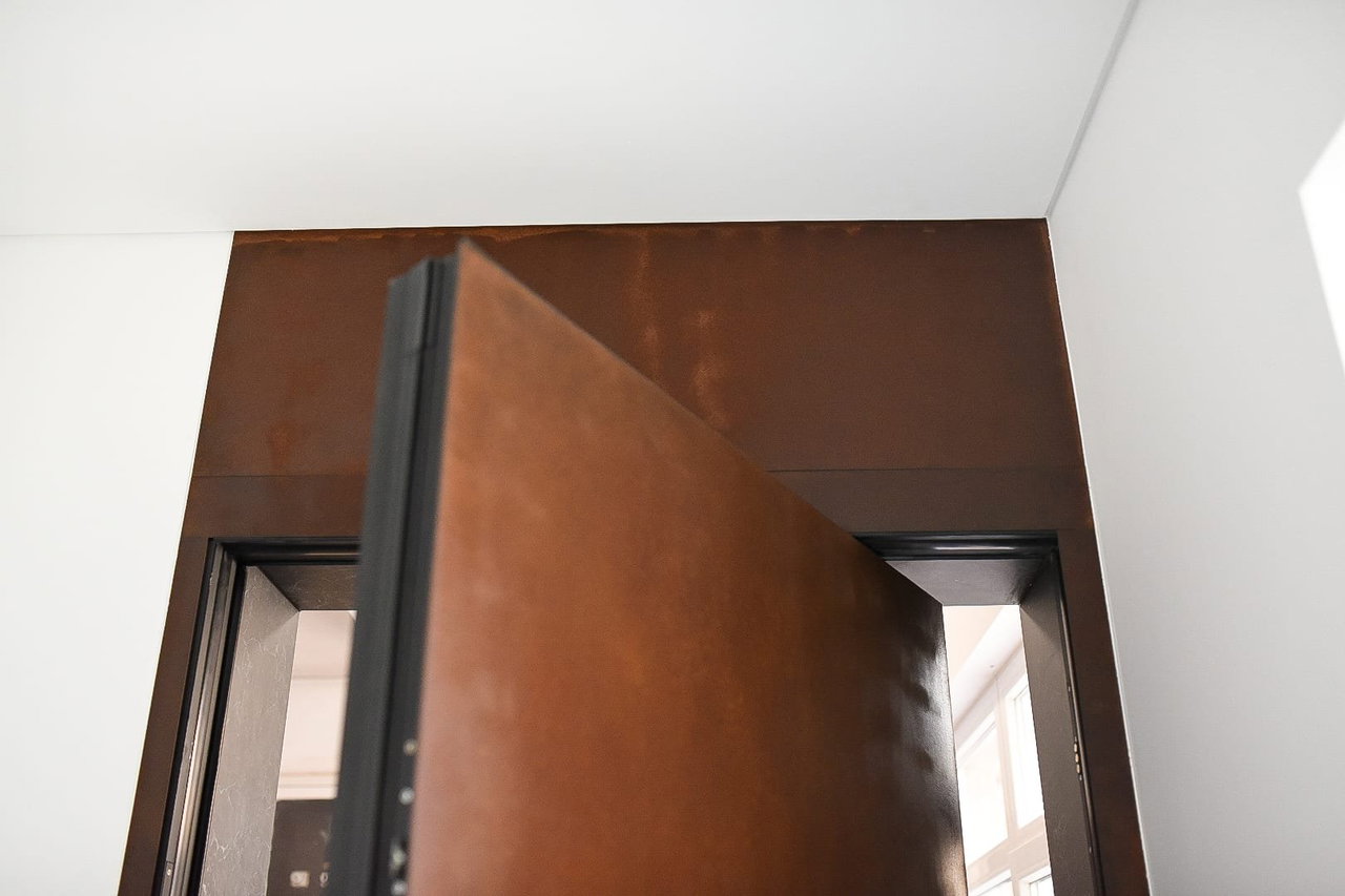 Steel pivot door in a private home in Osijek with FritsJurgens System One pivot hinge system inside