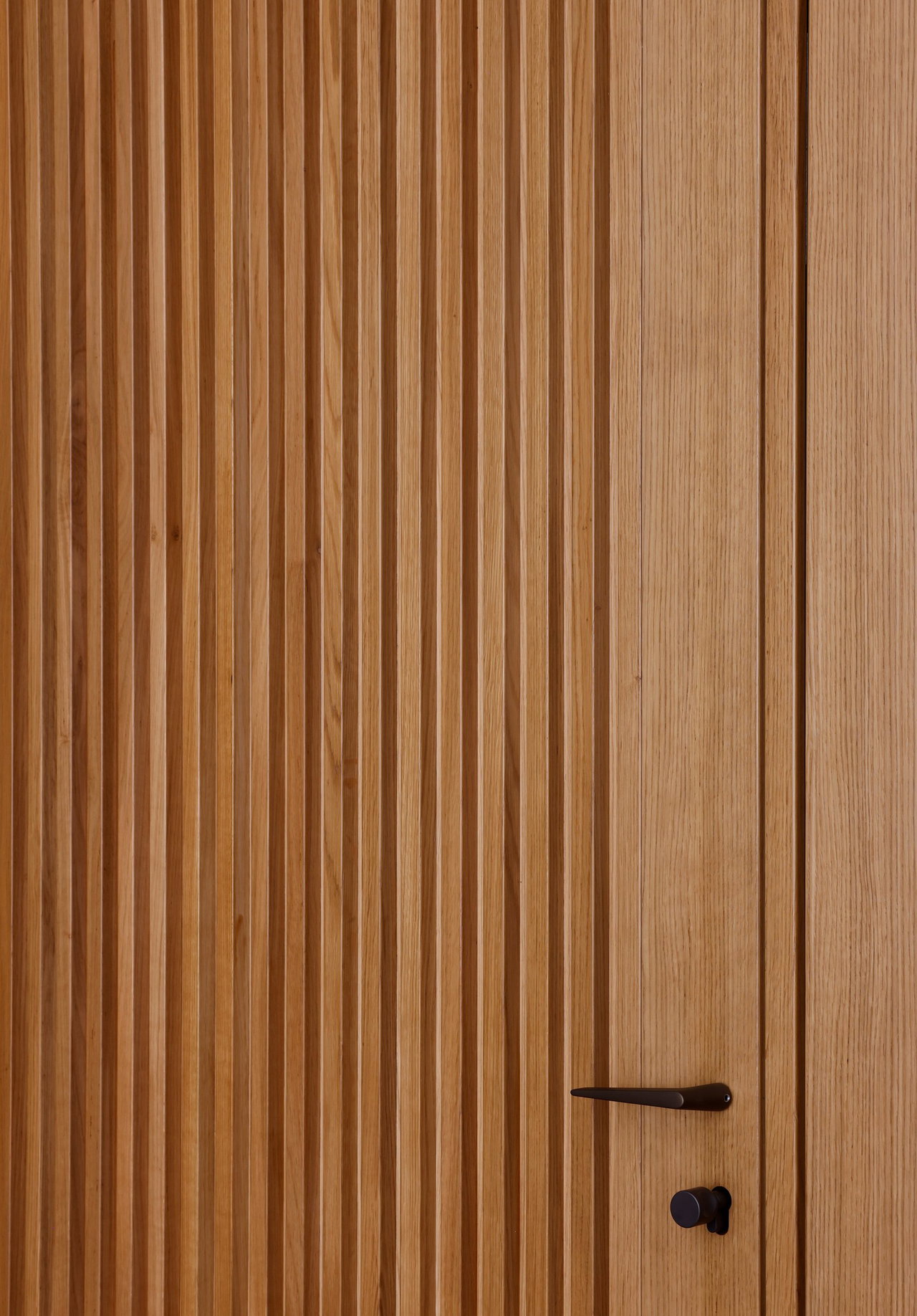 Wooden pivot door in a private home in Nassau with FritsJurgens System M+ pivot hinge system inside