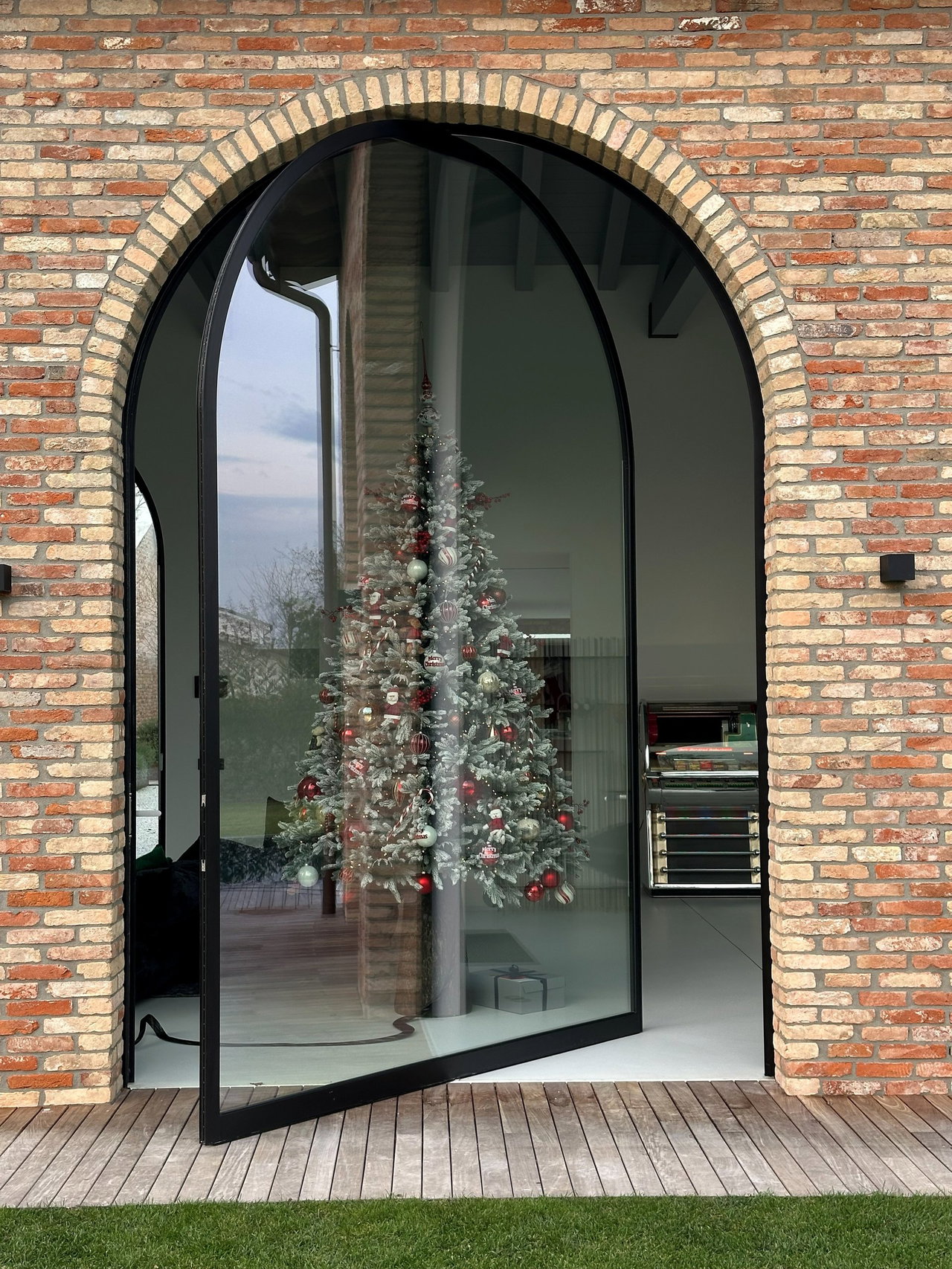 Steel and glass pivot door in a private home in Santa Lucia di Piave with FritsJurgens System One pivot hinge system inside
