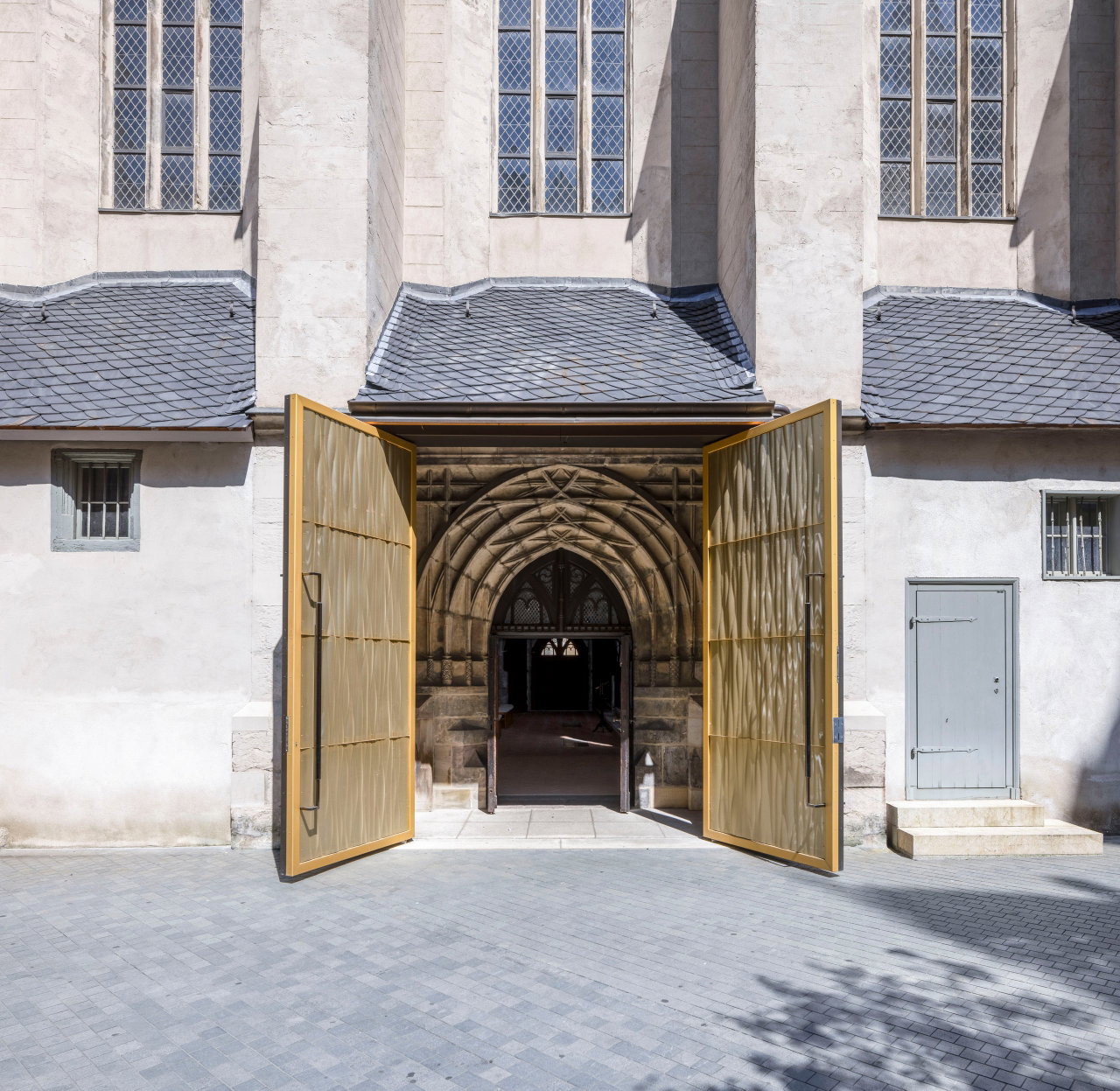 Aluminium pivot door in a religious building in Halle with FritsJurgens System M+ pivot hinge system inside
