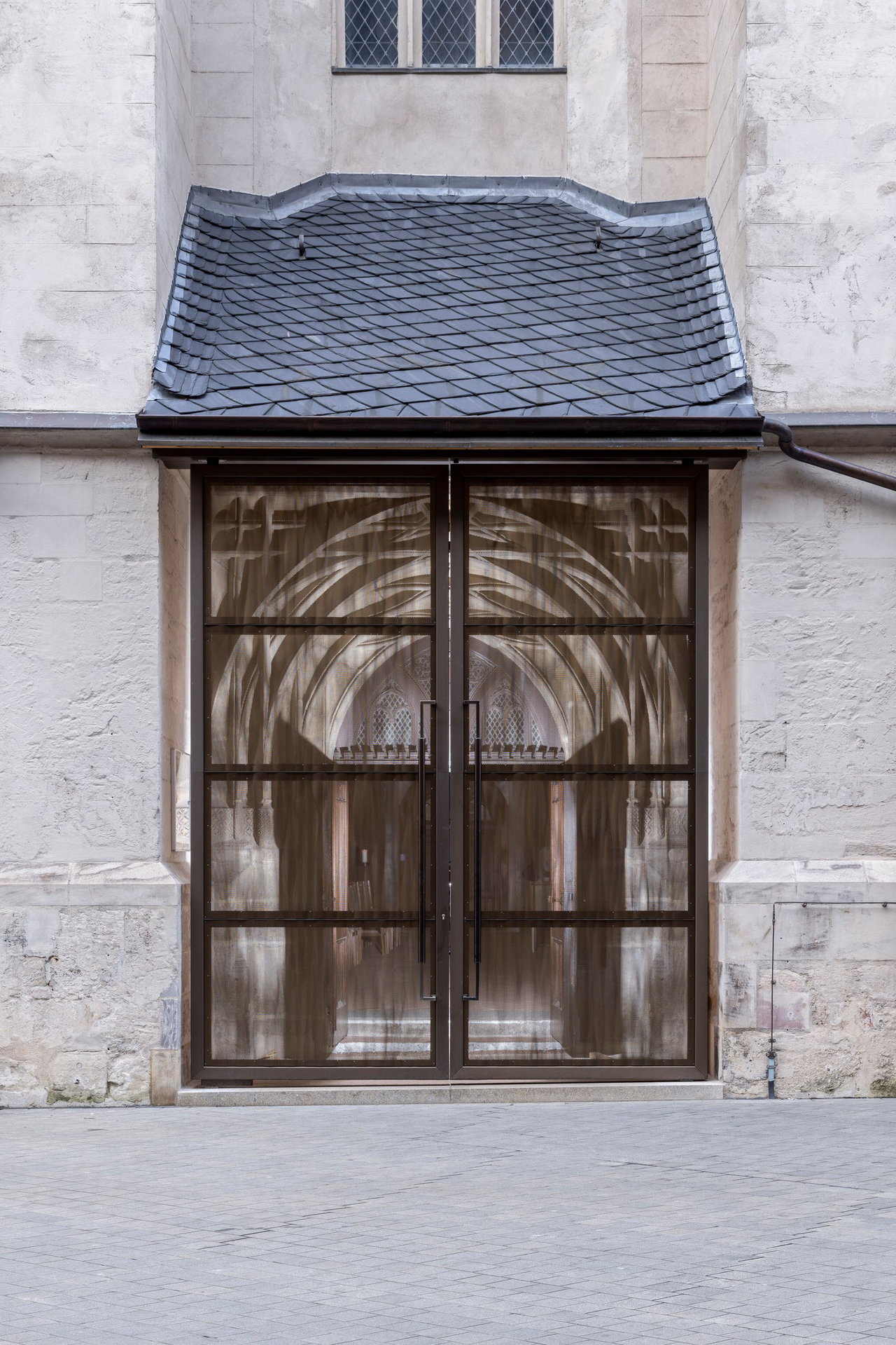 Aluminium pivot door in a religious building in Halle with FritsJurgens System M+ pivot hinge system inside