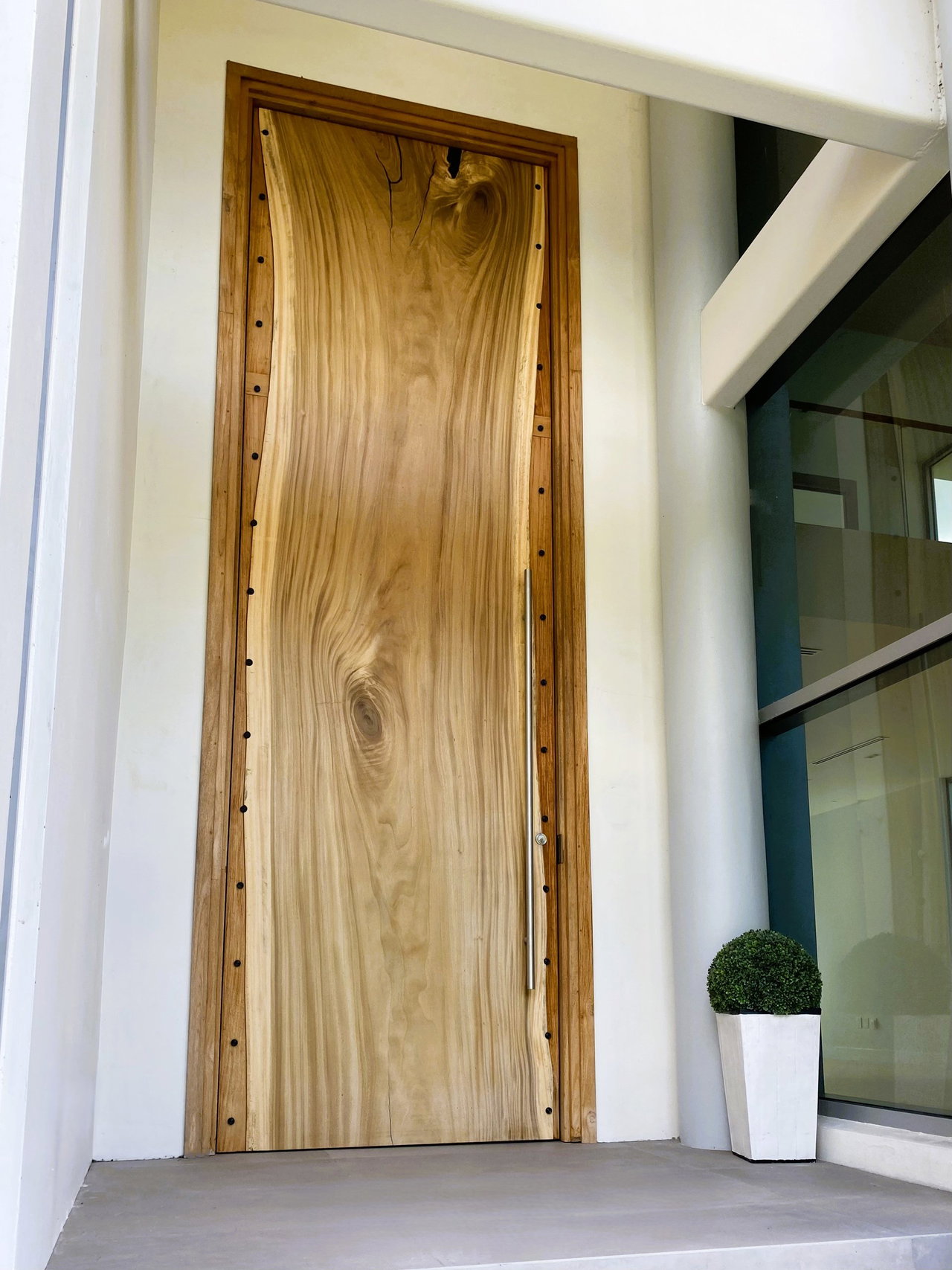 Wooden pivot door in a private home in Winter Park with FritsJurgens System M+ pivot hinge system inside