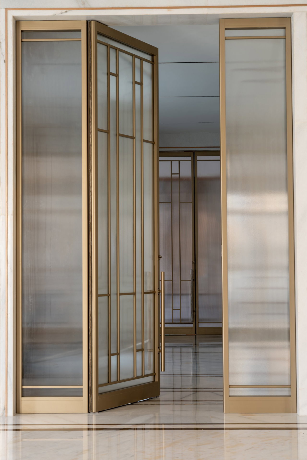 Steel and glass pivot door in a private home in Hyderabad with FritsJurgens System M+ pivot hinge system inside