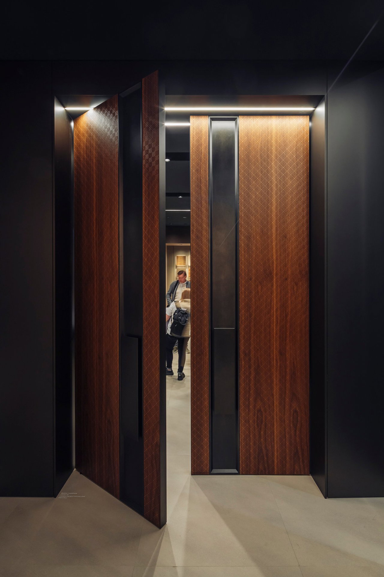 Wooden pivot door in a showroom in Milan with FritsJurgens System M+ pivot hinge system inside