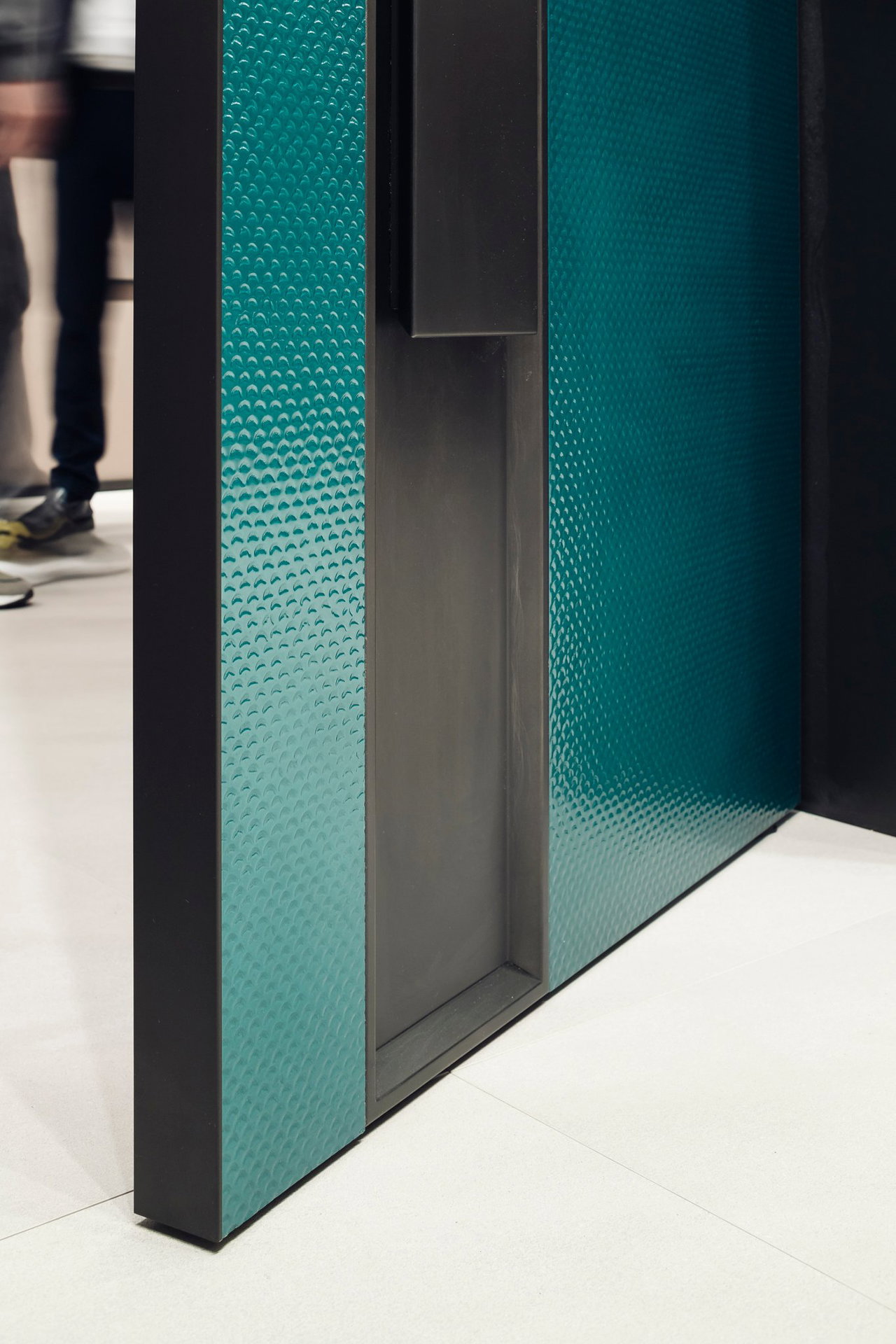 Wooden pivot door in a showroom in Milan with FritsJurgens System M+ pivot hinge system inside