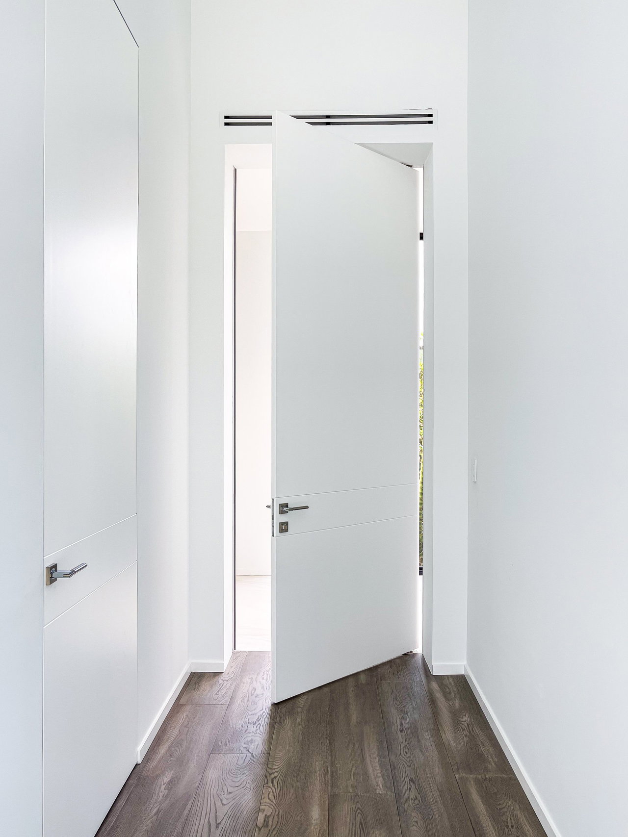 Wooden pivot door in a private home in Weston with FritsJurgens System One pivot hinge system inside