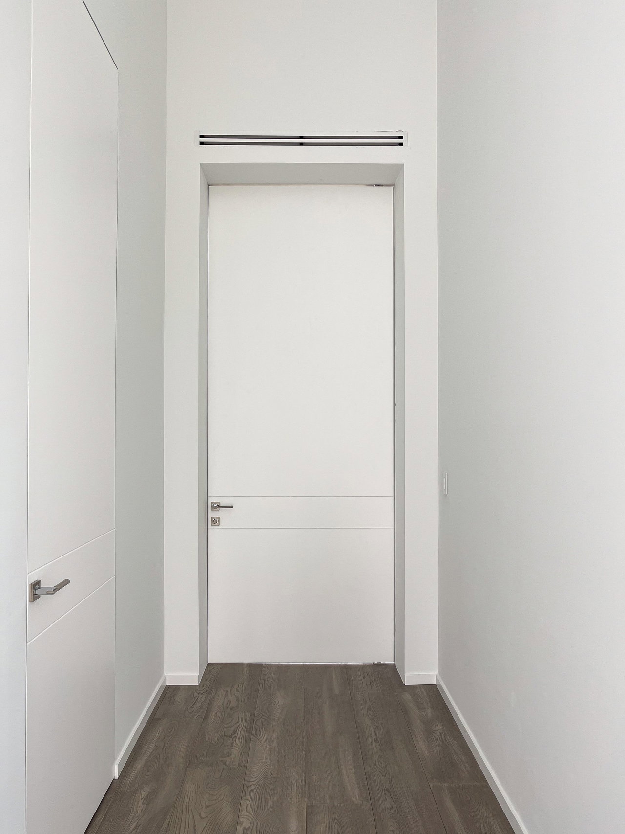 Wooden pivot door in a private home in Weston with FritsJurgens System One pivot hinge system inside