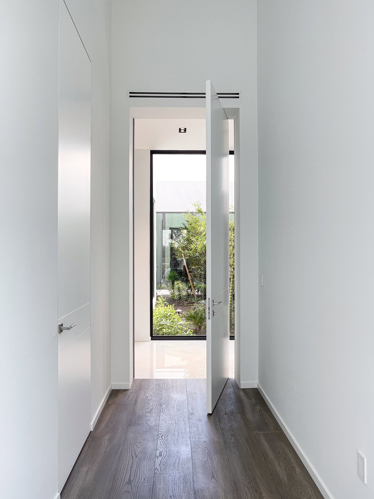 Wooden pivot door in a private home in Weston with FritsJurgens System One pivot hinge system inside
