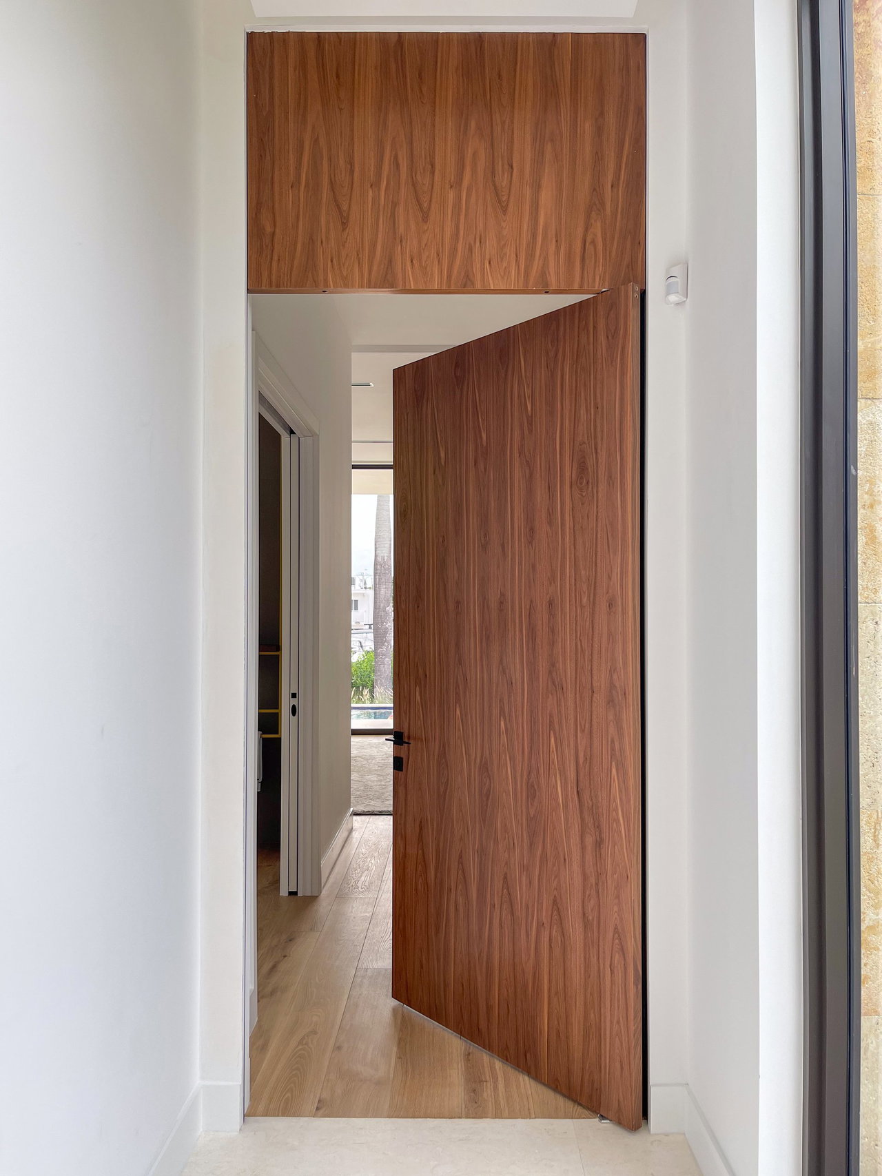 Wooden pivot door in a private home in Miami with FritsJurgens System One pivot hinge system inside