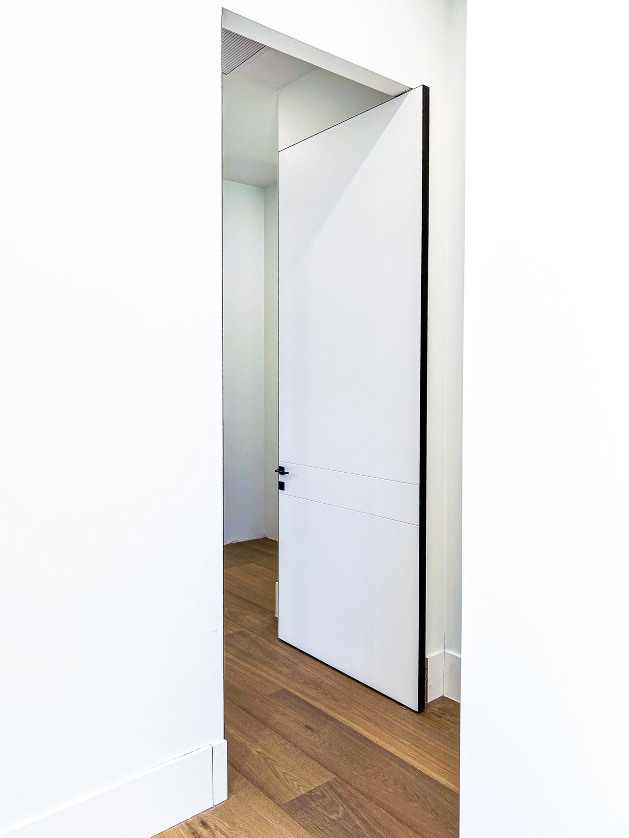 Aluminium pivot door in a private home in Naples, Florida with FritsJurgens System One pivot hinge system inside