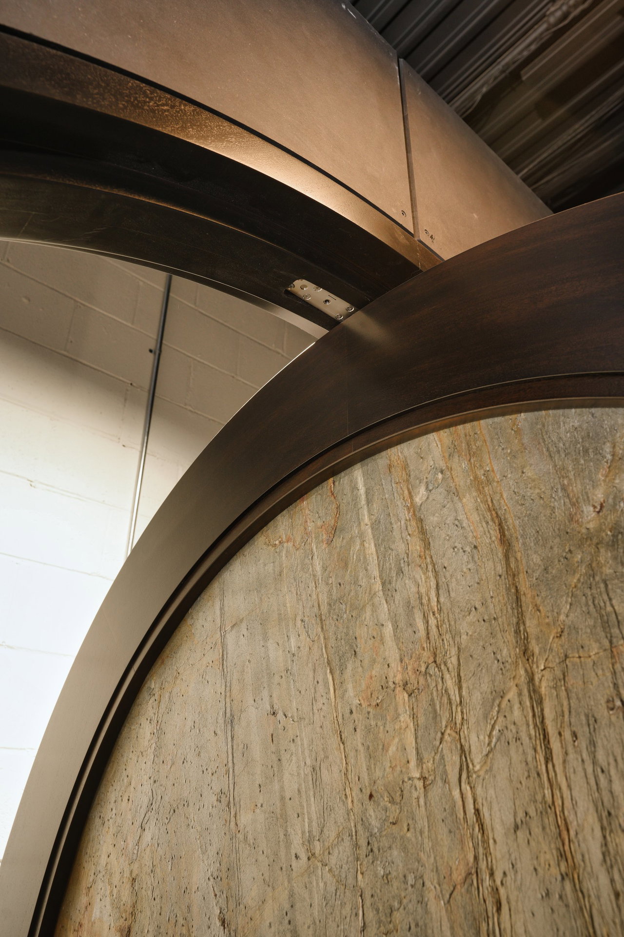 Stone pivot door in a private home in Los Angeles with FritsJurgens System M+ pivot hinge system inside