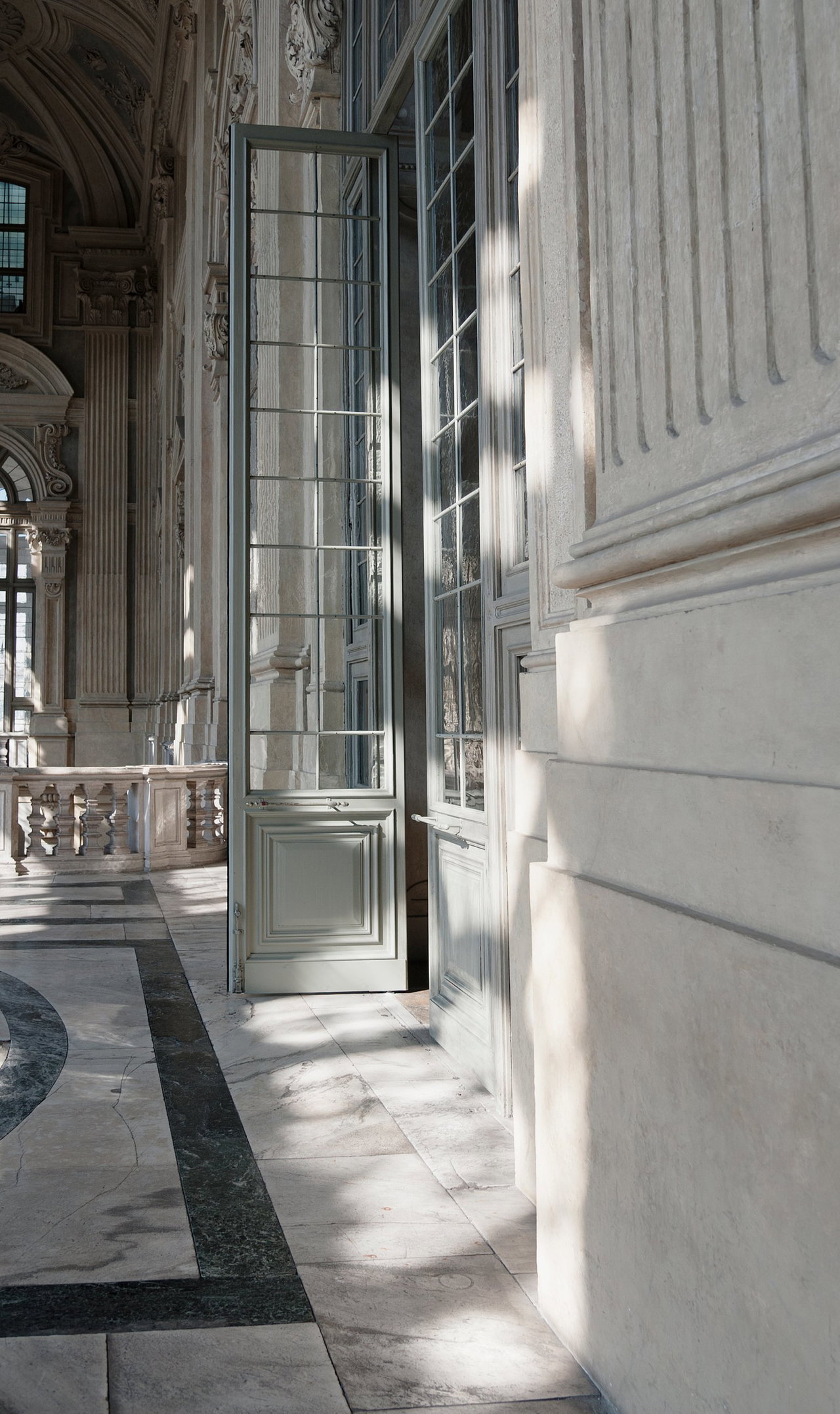 Wooden pivot door in a public building in Turin with FritsJurgens System M pivot hinge system inside