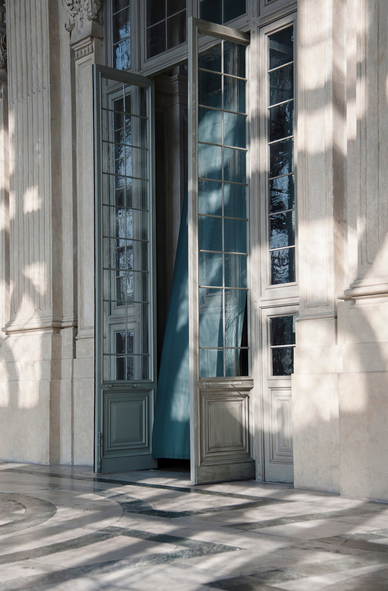 Wooden pivot door in a public building in Turin with FritsJurgens System M pivot hinge system inside