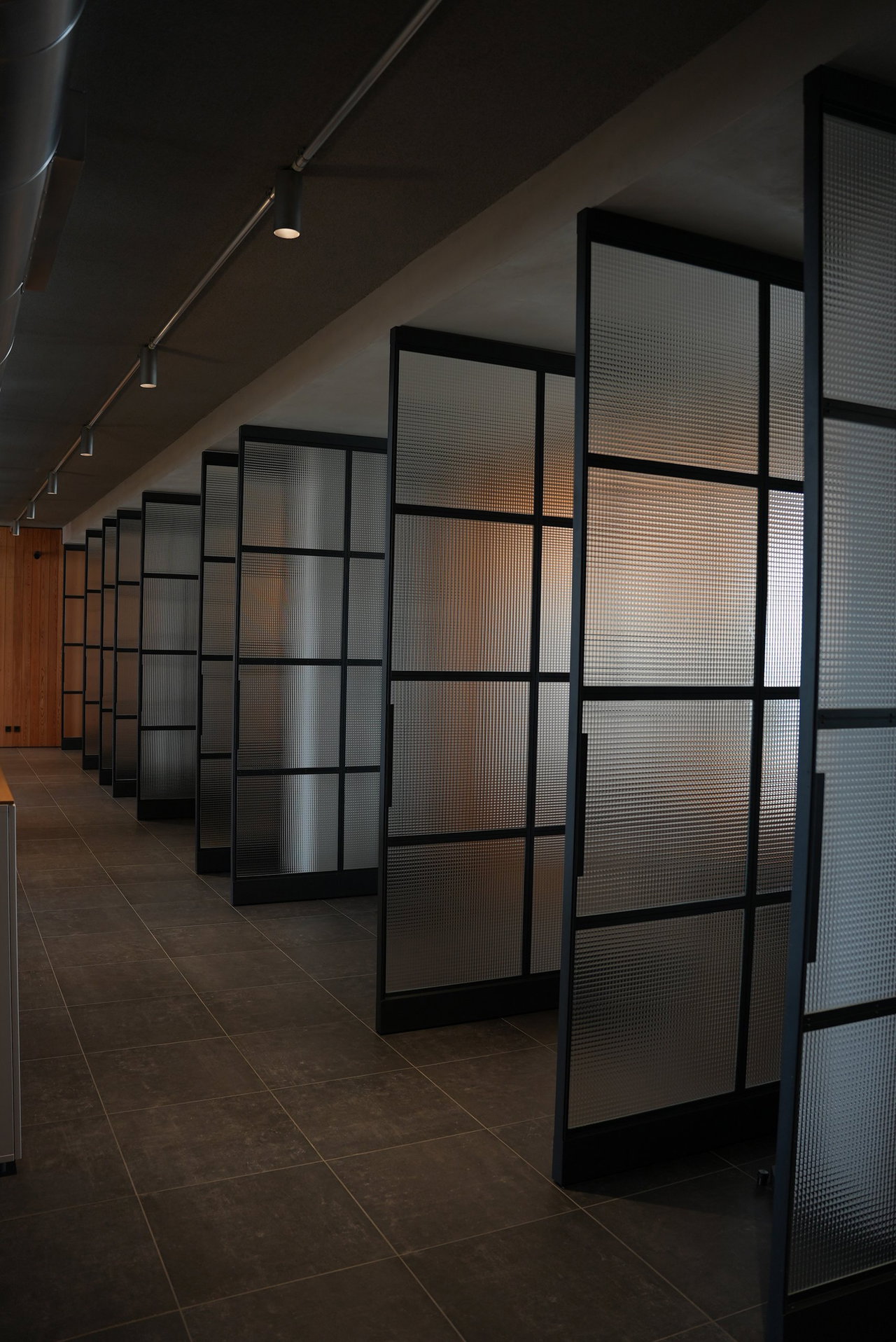 Puerta pivotante de acero y vidrio en una oficina en Lisboa con bisagra pivotante FritsJurgens System M+ en el interior