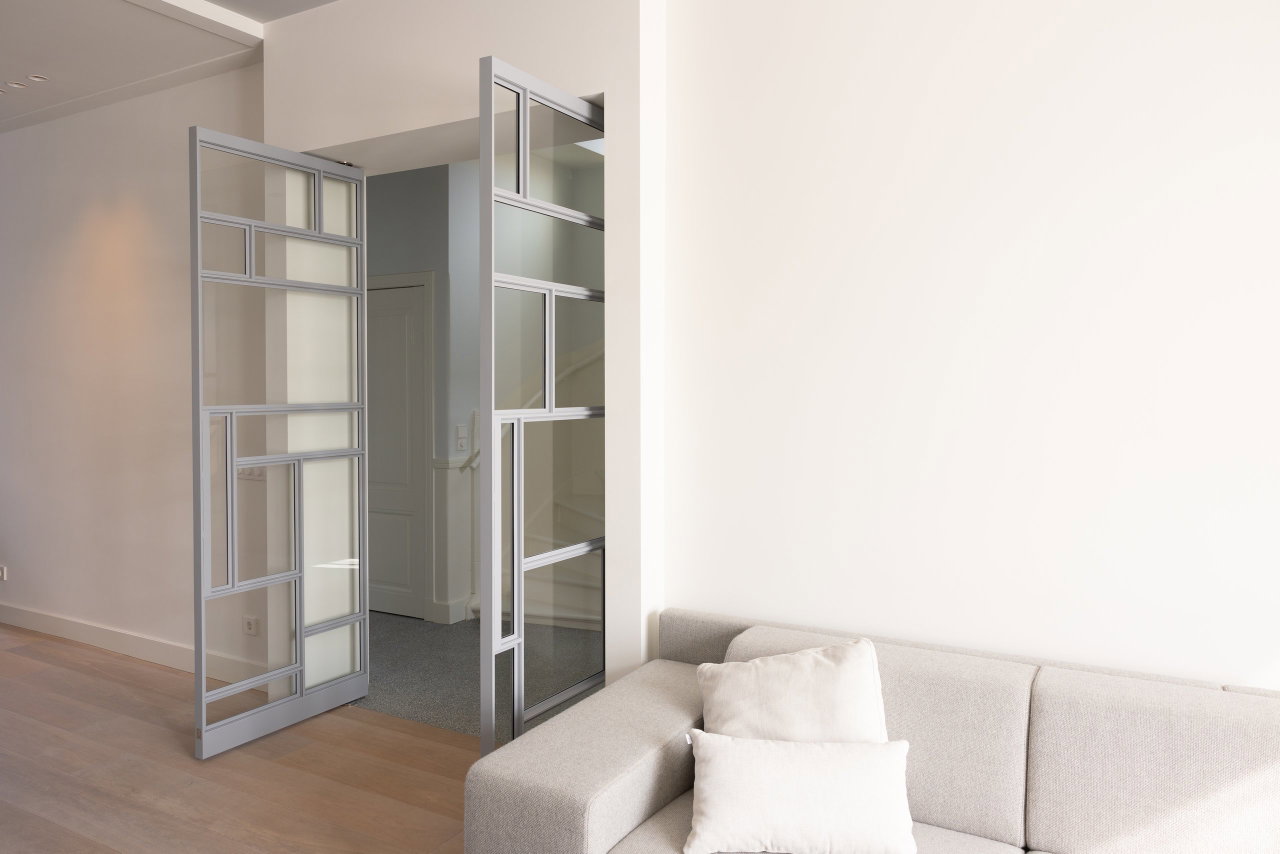 Pivottür aus Stahl und Glas in einem Privathaus in Utrecht mit FritsJurgens System M Pivot-Scharniersystem im Inneren