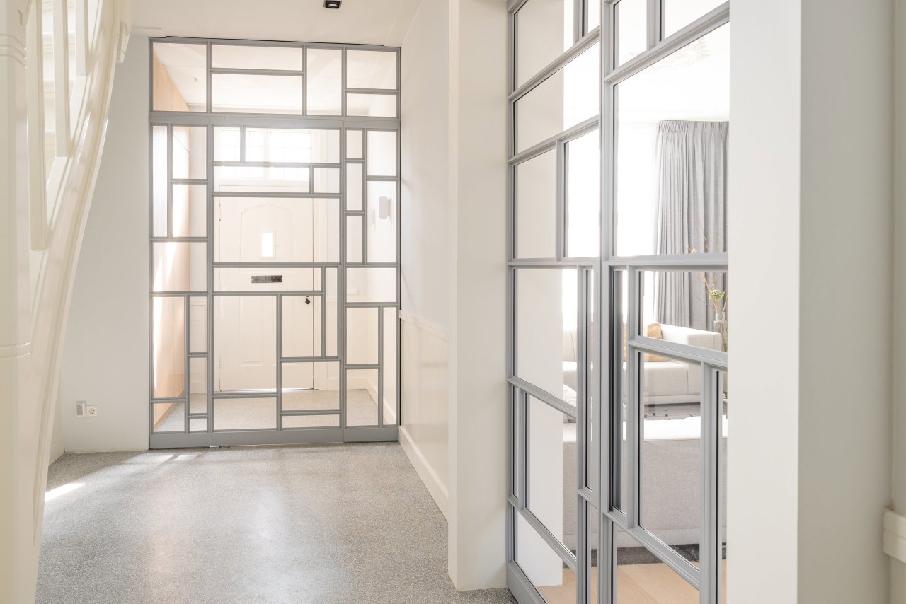 Pivottür aus Stahl und Glas in einem Privathaus in Utrecht mit FritsJurgens System M Pivot-Scharniersystem im Inneren