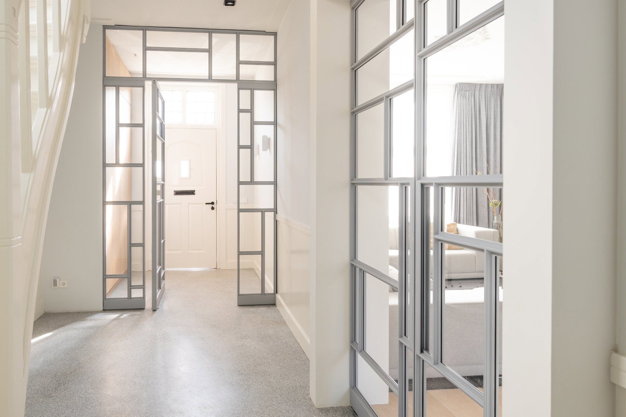Pivottür aus Stahl und Glas in einem Privathaus in Utrecht mit FritsJurgens System M Pivot-Scharniersystem im Inneren
