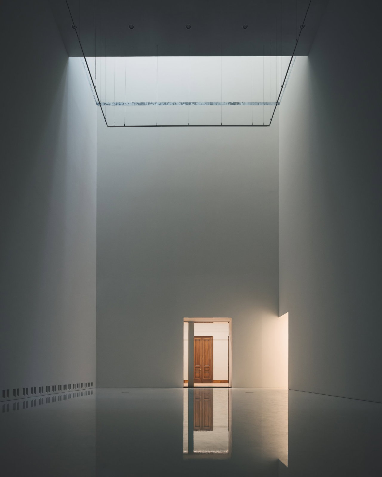 Wooden pivot door in a public building in Antwerp with FritsJurgens System One pivot hinge system inside