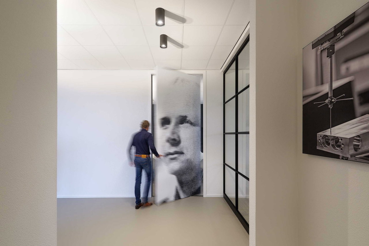 Steel and glass pivot door in an office in Kolham with FritsJurgens System One pivot hinge system inside