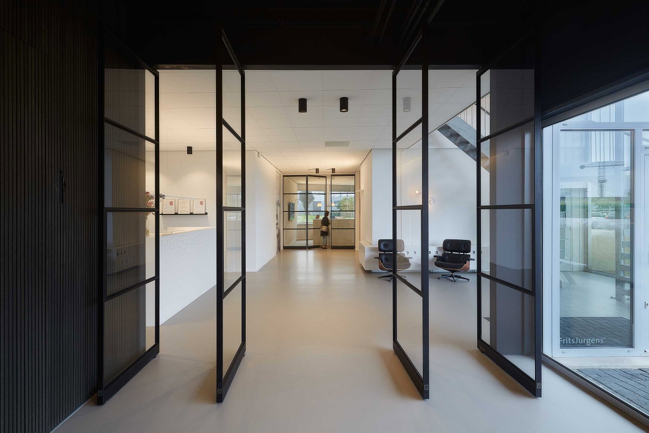 Steel and glass pivot door in an office in Kolham with FritsJurgens System One pivot hinge system inside