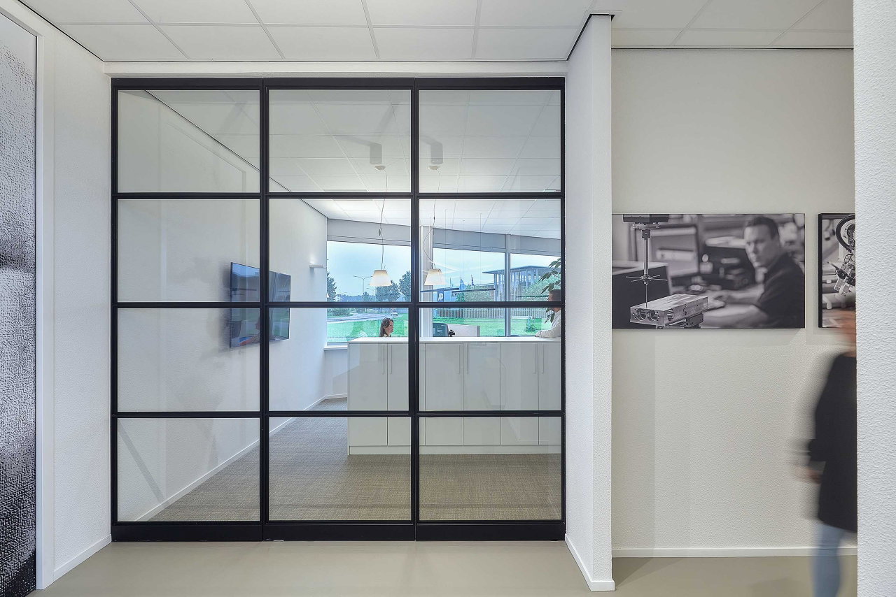 Steel and glass pivot door in an office in Kolham with FritsJurgens System One pivot hinge system inside
