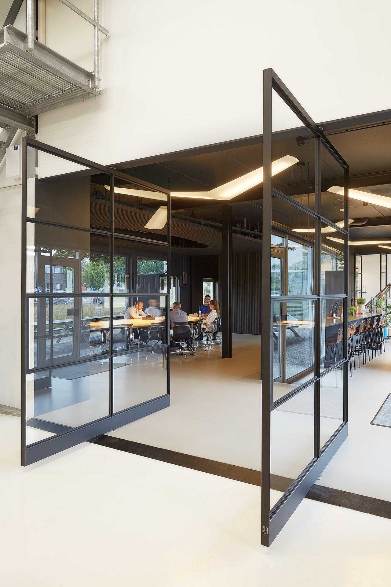 Steel and glass pivot door in an office in Kolham with FritsJurgens System One pivot hinge system inside