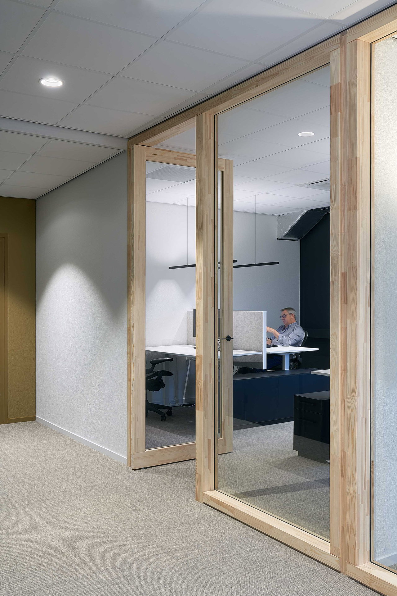 Steel and glass pivot door in an office in Kolham with FritsJurgens System One pivot hinge system inside