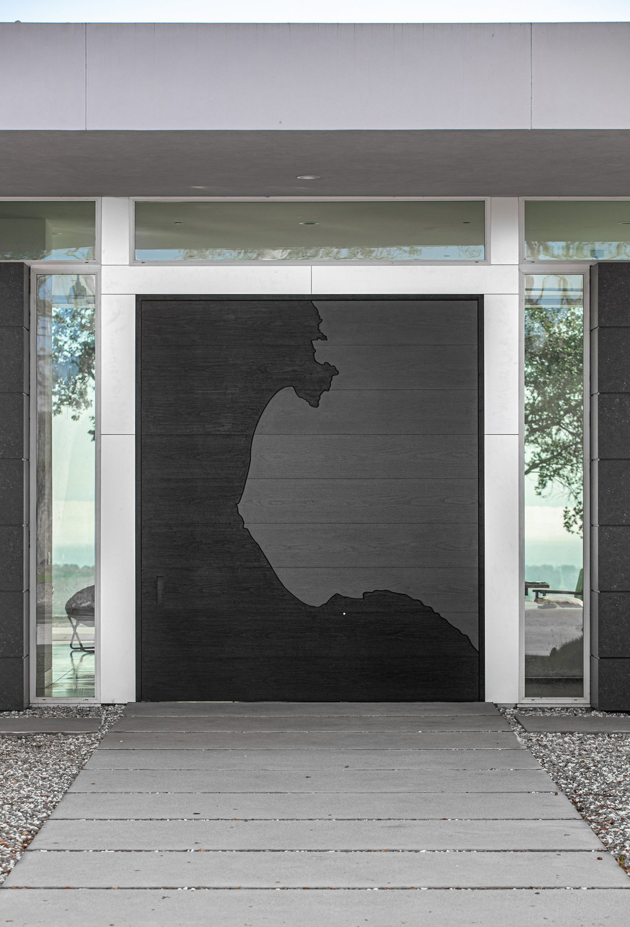 Wooden pivot door in a private home in Santa Cruz with FritsJurgens System M pivot hinge system inside
