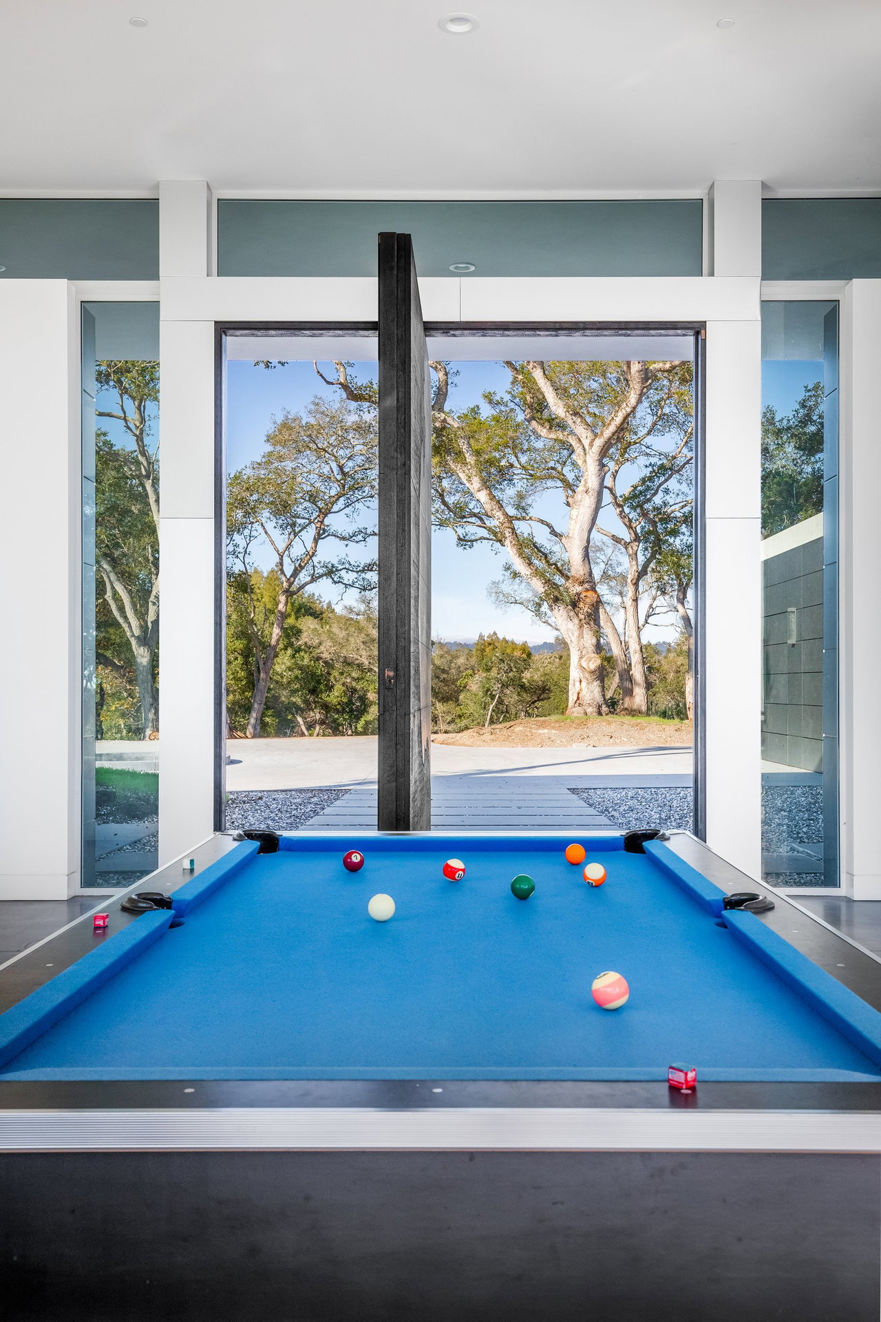 Wooden pivot door in a private home in Santa Cruz with FritsJurgens System M pivot hinge system inside